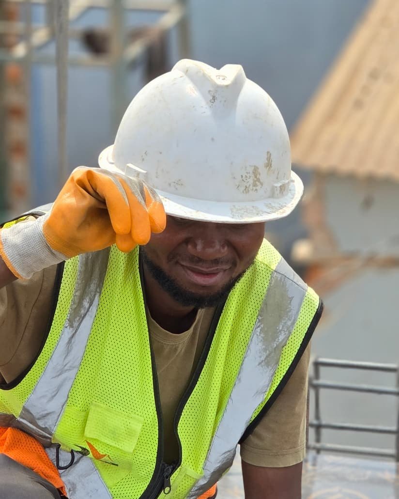 Ouvrier en casque blanc et gilet jaune haute visibilité travaillant sur un chantier de bâtiment